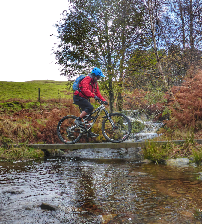 Cycling across a plank over a river