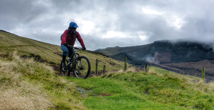 A mountain biker summits a slight slope on the Trans Cambrian Way