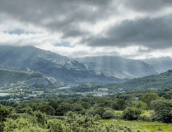 The light shafts down through the clouds toward Llanberis, a great view earned by taking on a challenging walk.