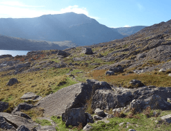 A rocky path through the mountains and around a lake on the Snowdon Round walking holiday, a walk that takes confidence to tackle.