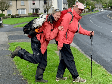 Two walkers pose in important hiking gear: their waterproof outer layers.