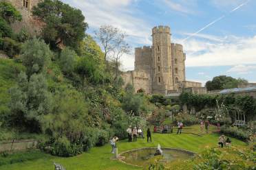 Windsor by Dmitry Djouce. Views over the green gardens of Windsor with the castle tower in the background and a round pond in the foreground.