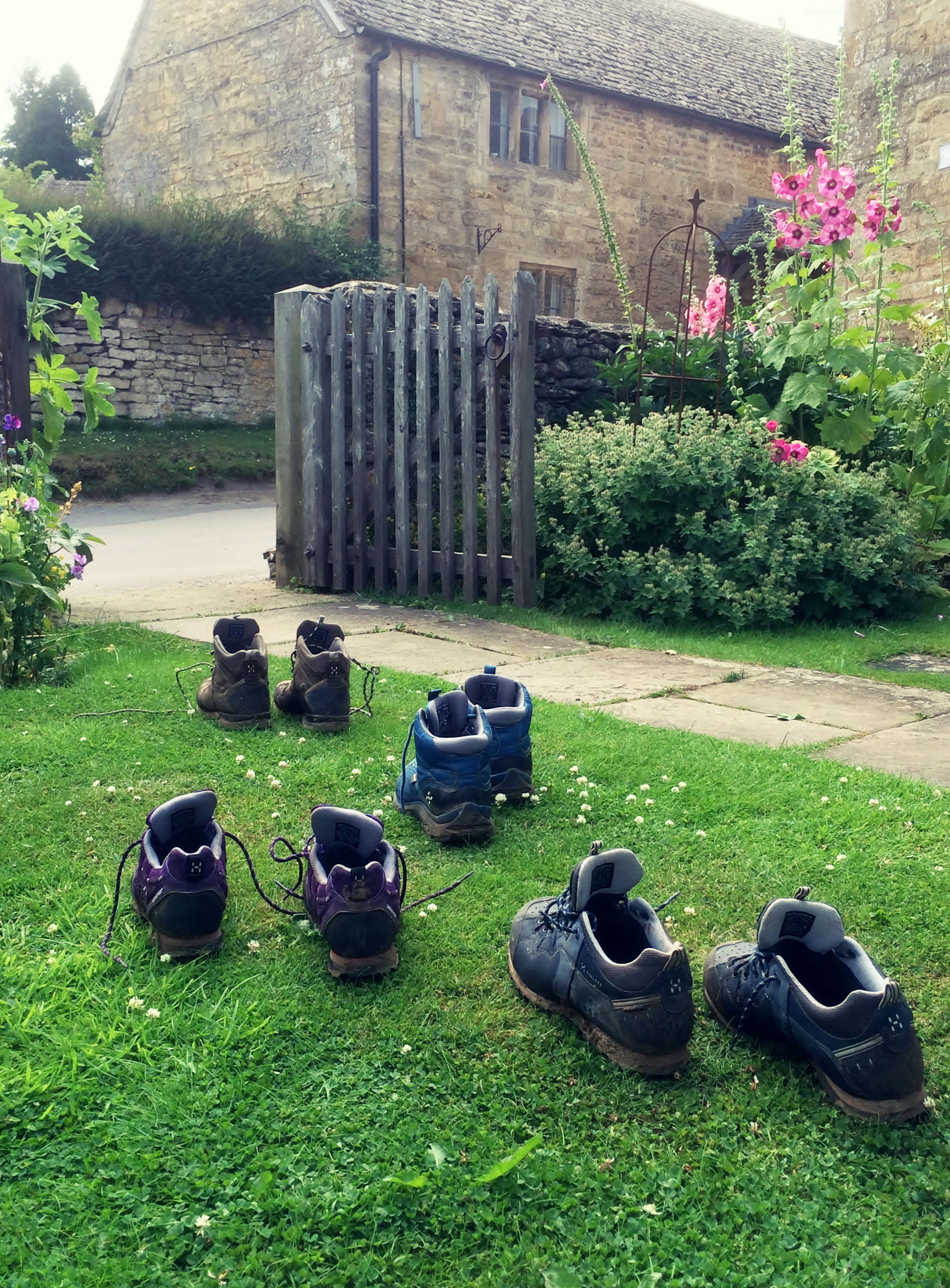 Walking boots sit outside in the garden to dry after a walk.